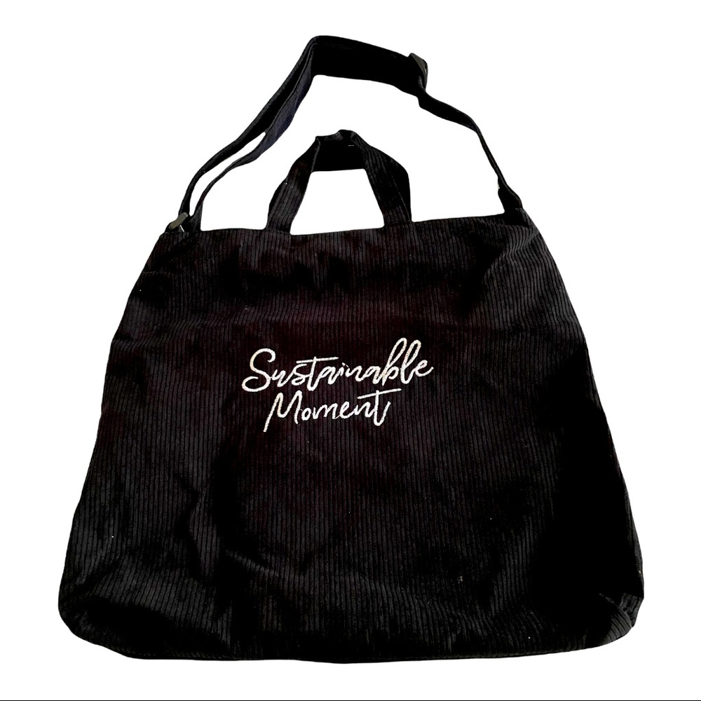 Black corduroy bag with zipper closure and adjustable strap. Brand new.